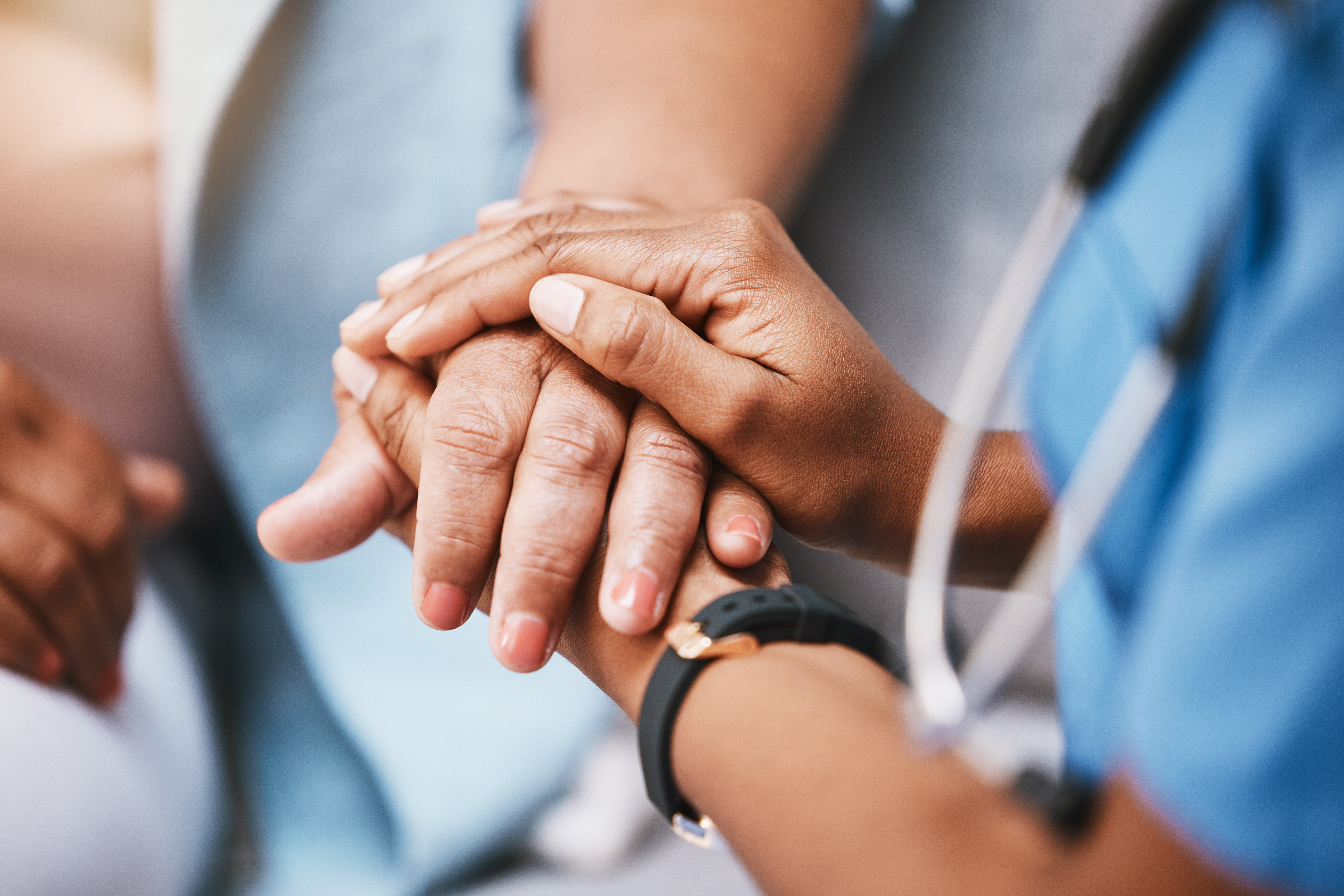 Uncropped photo of nurse's hands holding hands with a patient for consulting support and healthcare advice