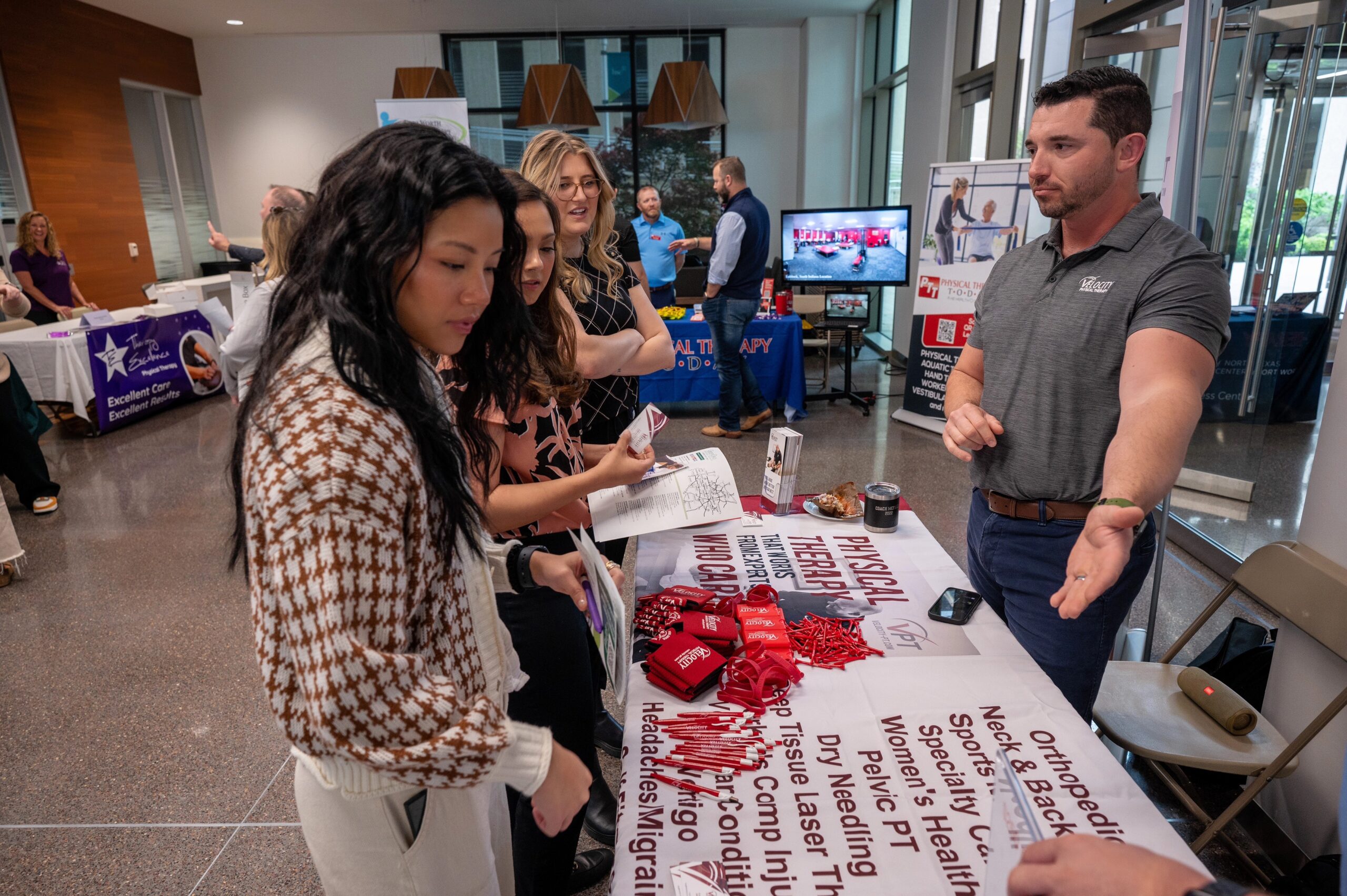 Physical therapy career fair attendees speaking to vendors