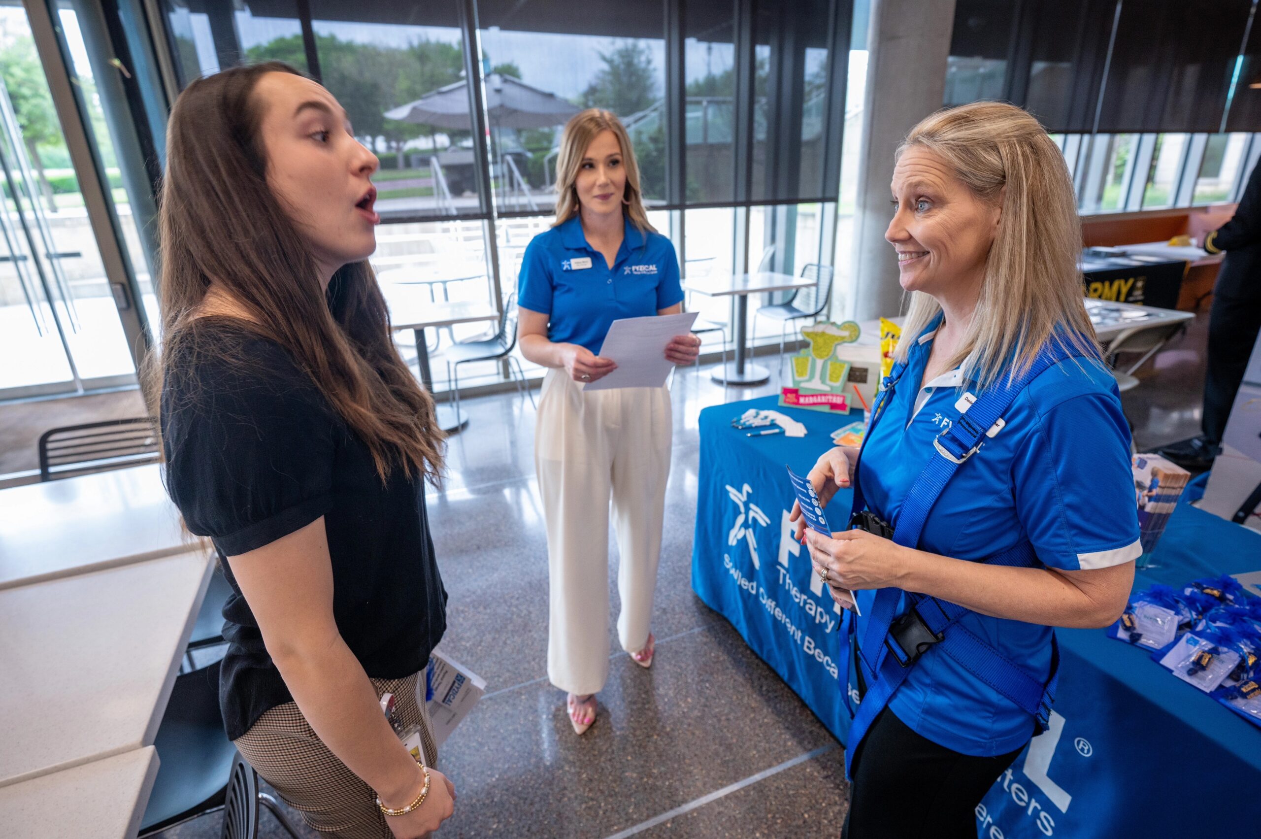 Physical therapy career fair attendees speaking to vendors