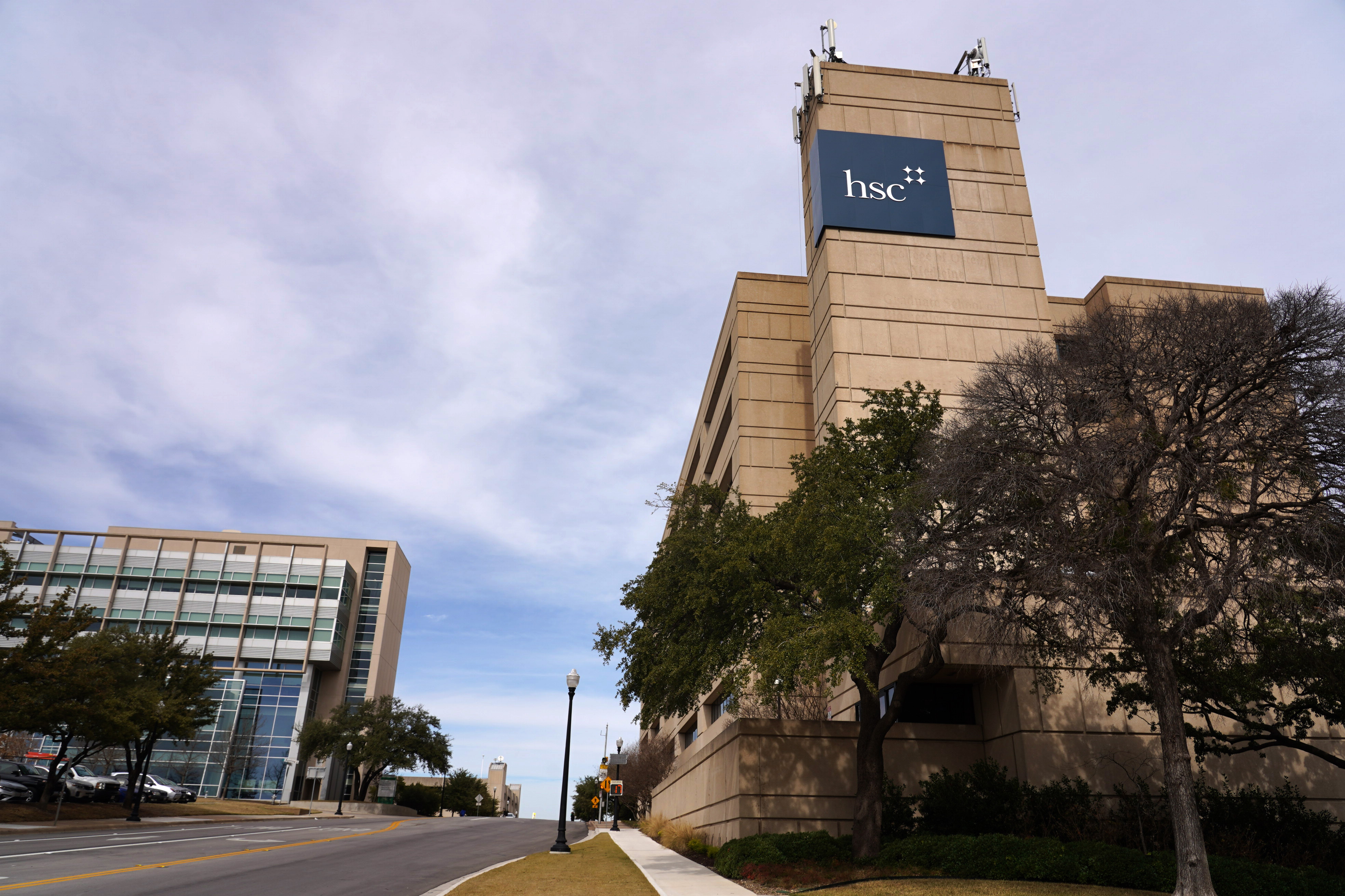 Photo of UNTHSC 7 story building on campus with HSC logo signage