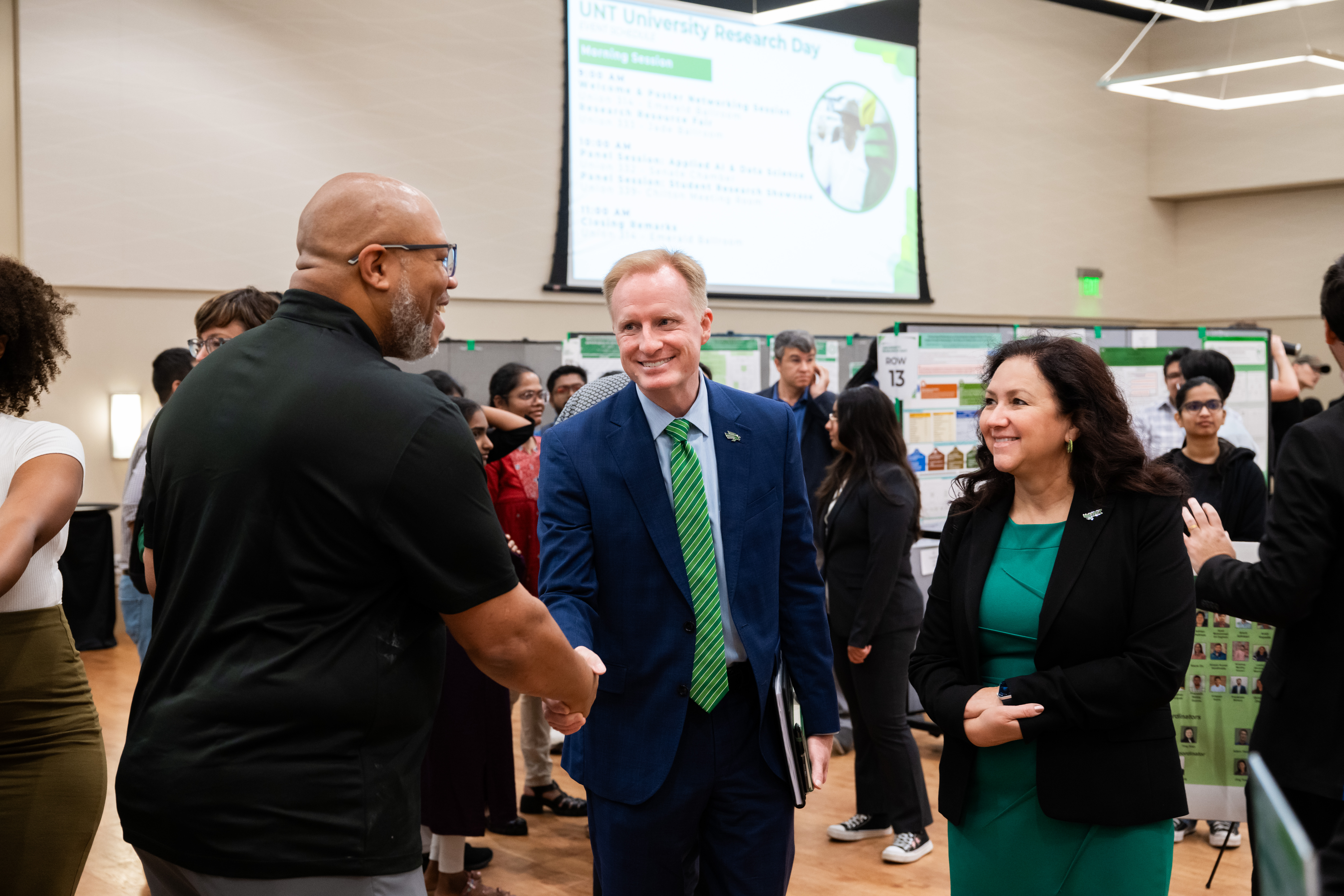 Photo of UNT President Harrison Keller and Vice President of Research and Innovation Pamela Padilla greet attendees at University Research Day