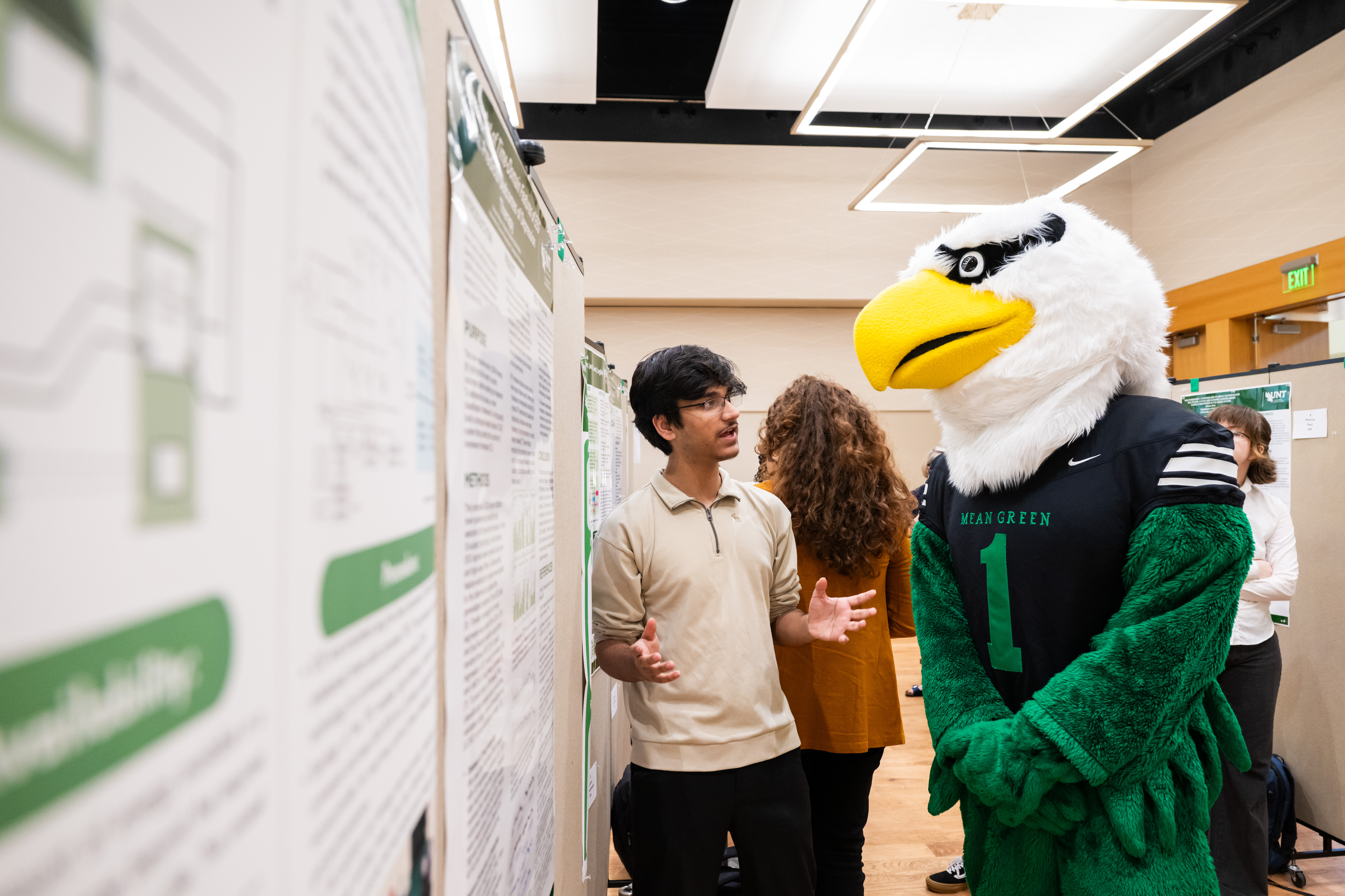 Photo of UNT eagle mascot, Scrappy learns about research happening at UNT.