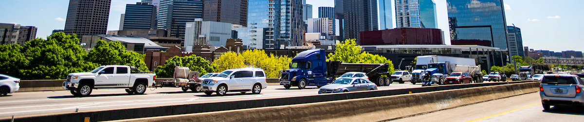 Cropped horizontal photo of busy highway traffic in front of the downtown Dallas skyline Top horizontal, narrow-cropped photo banner of busy highway traffic in front of the downtown Dallas skyline