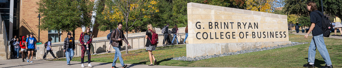 UNT students walking past the G. Brint Ryan College of Business building on campus. Top, wide banner photo of UNT students walking past the G. Brint Ryan College of Business building on campus.