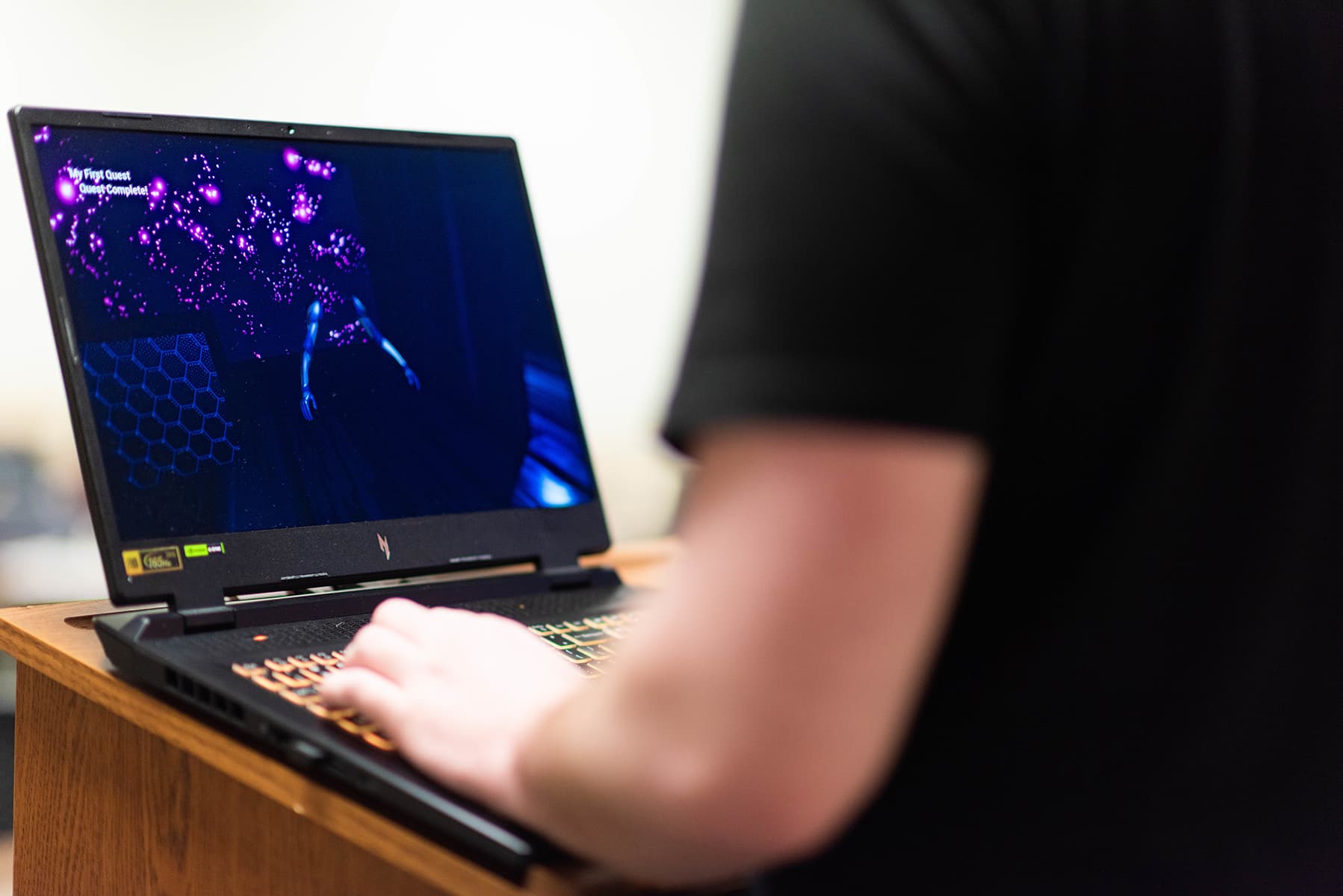 Photo of a UNT student is using a laptop to work on their game design project