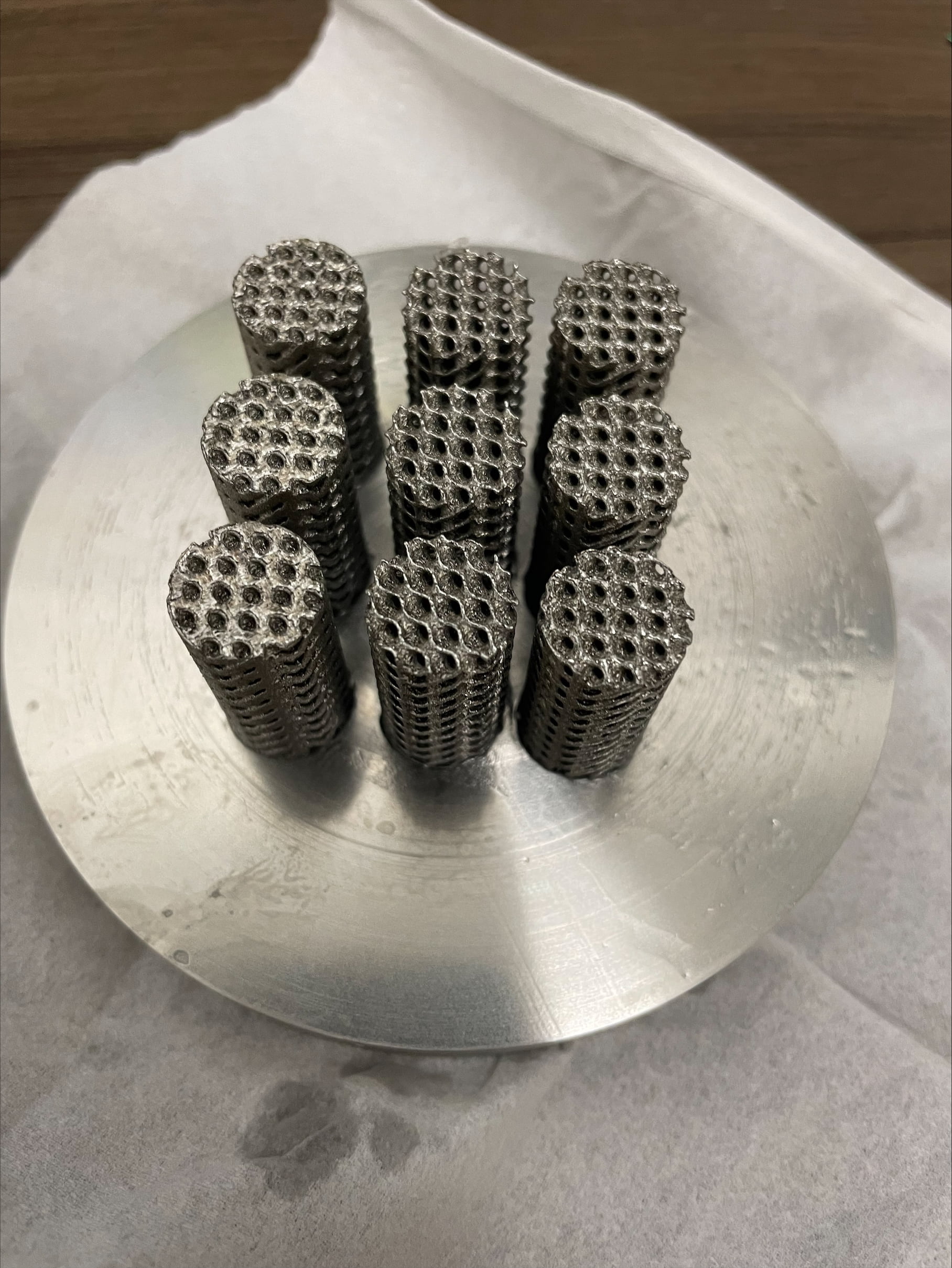 Photo of nine of the cylindrical lattices made of stainless steel