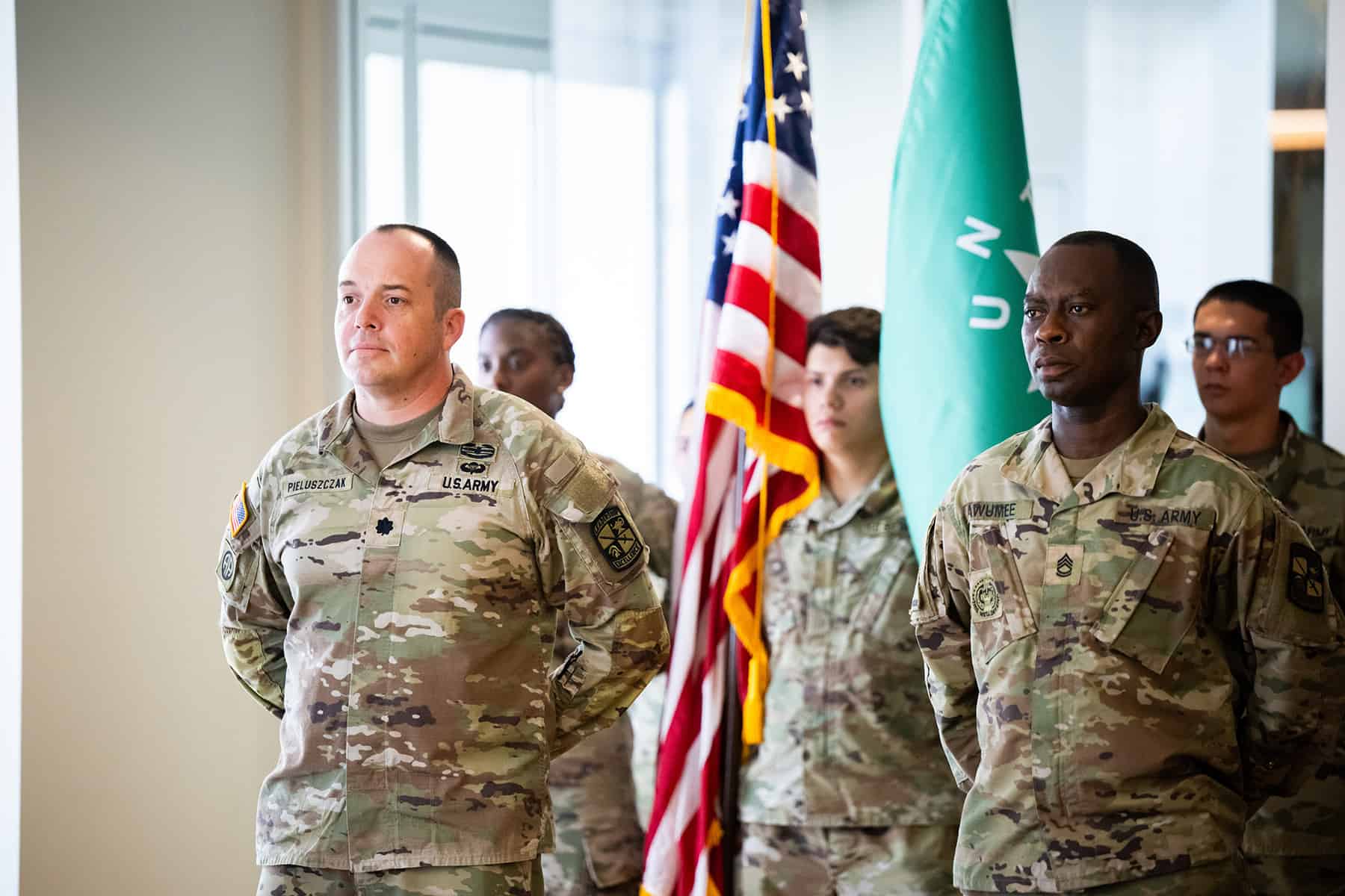 Photo of Lt. Col. Scott Pieluszczak (far left) stands with other members of the UNT Army ROTC battalion in front of the US and UNT ROTC battalion flag.