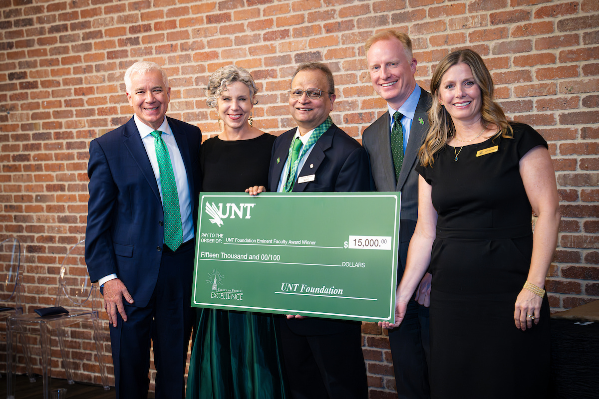 Photo of a group of five people with UNT's Francis D'Souza in the middle holding a large check