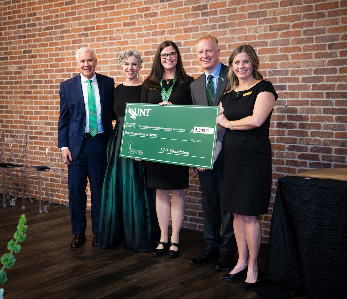 Photo of a group of five people with Brenda Sweeten in the middle holding a large check
