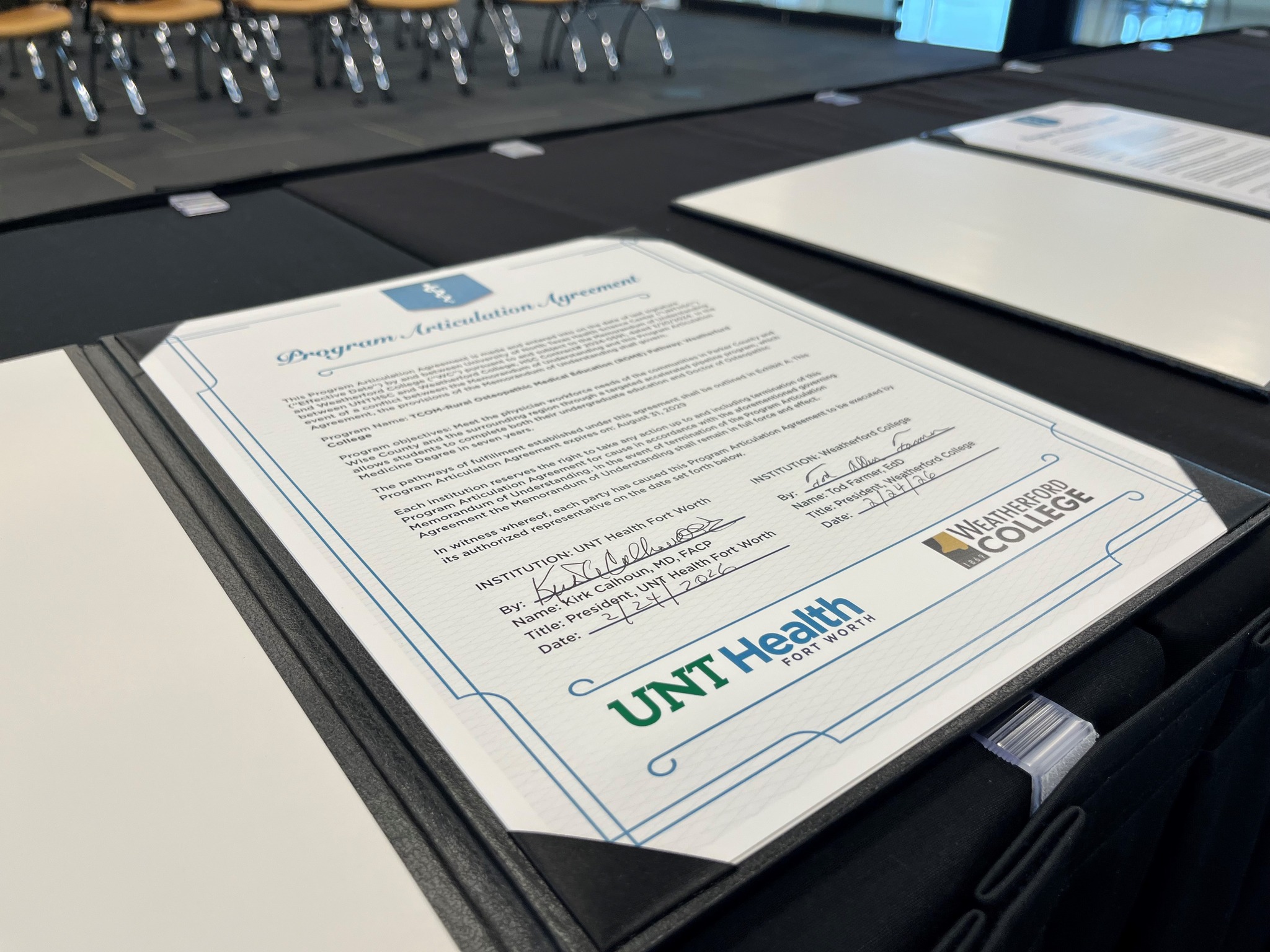 Signed Program Articulation Agreement document between UNT Health Fort Worth and Weatherford College displayed on a signing table at a formal ceremony. Photo of signed Program Articulation Agreement document between UNT Health Fort Worth and Weatherford College displayed on a signing table at a formal ceremony.