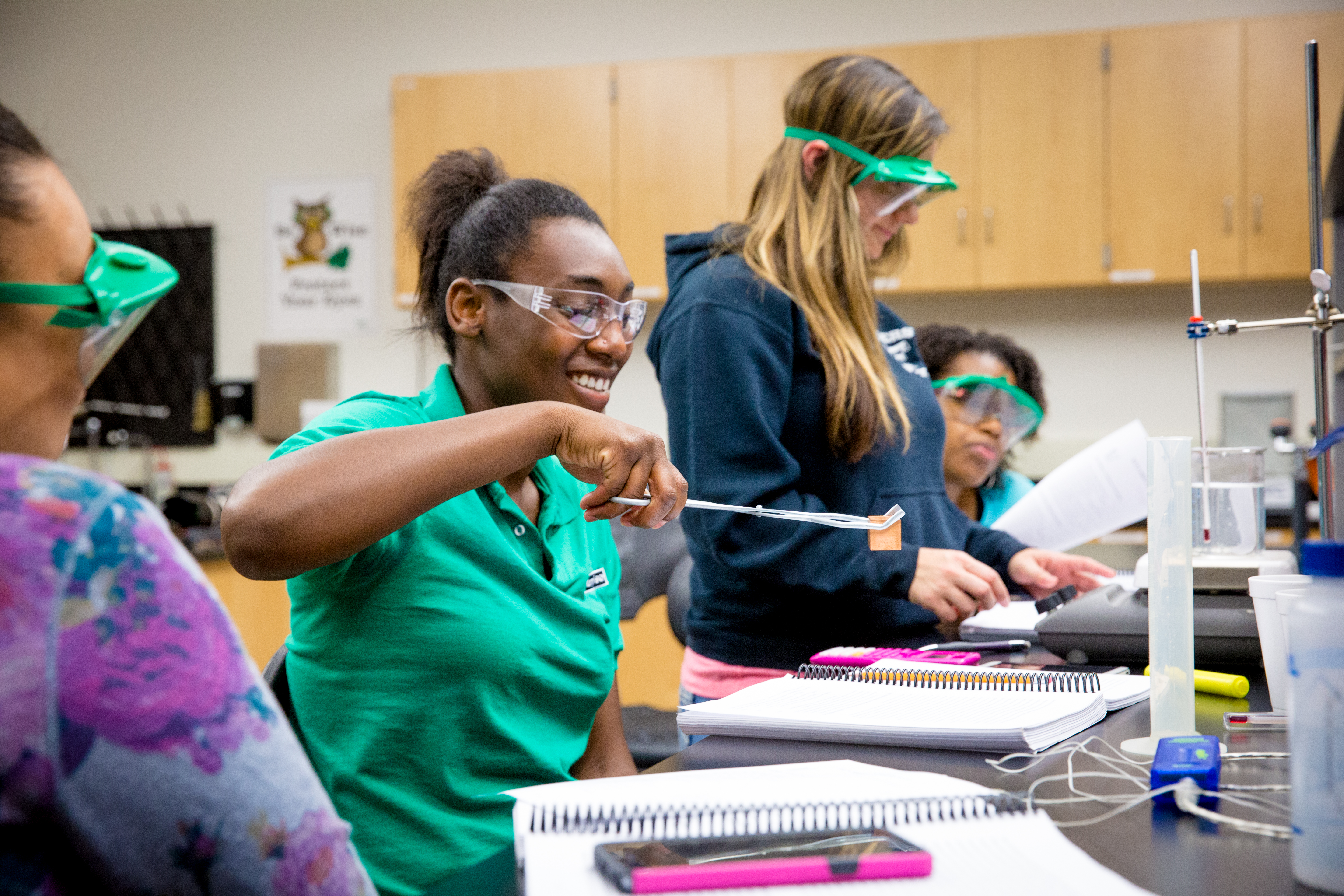 Photo of 4 UNT Dallas students getting hands-on experience in a chemistry lab 