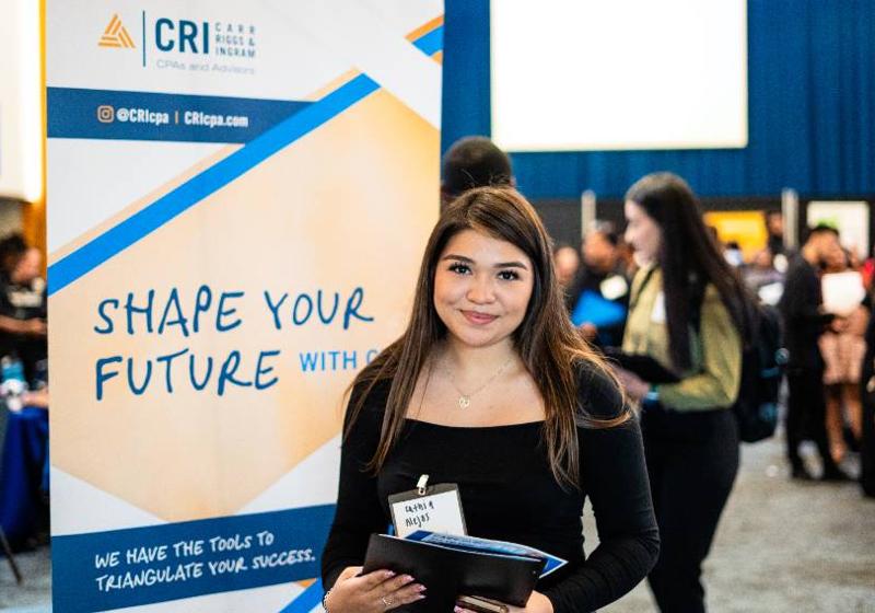 Photo of a female student visiting a Career Fair at UNT Dallas, where AI related skills and opportunities will be discussed by employers and students