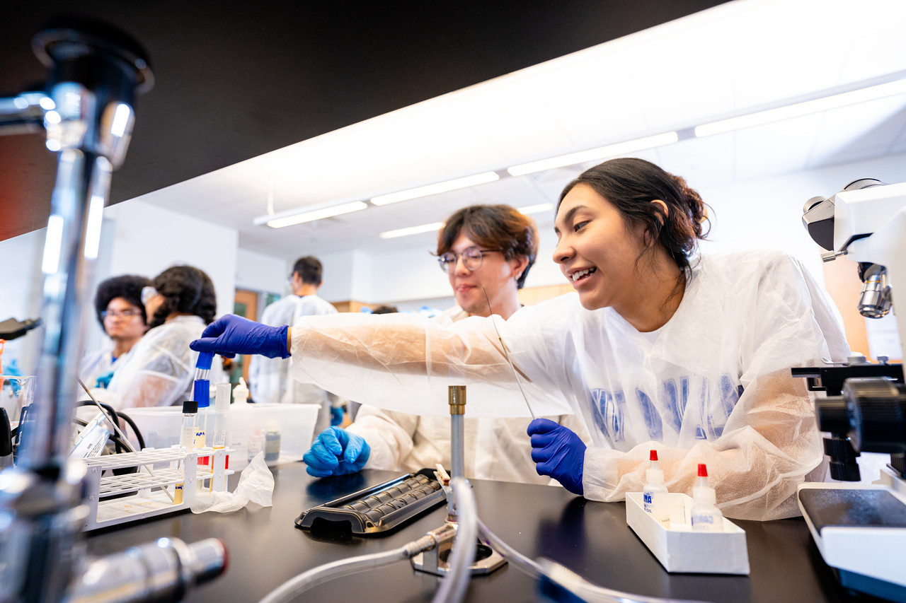 A photo of UNT Dallas students work in a science lab, an example of hands-on, experiential learning. 
