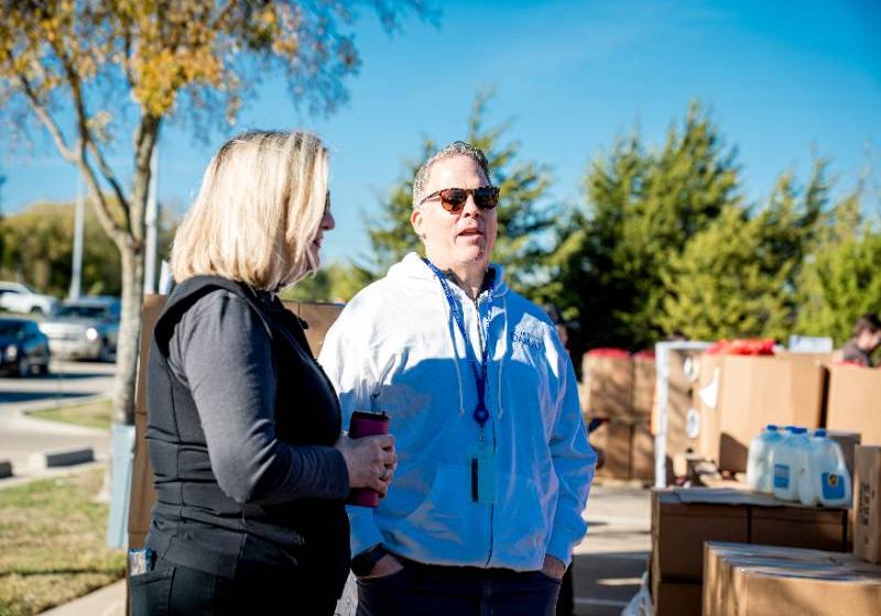 Photo of UNT Dallas's President Dr. Warren von Eschenbach speaks with a volunteer at a UNT Dallas-NTFB Mobile food pantry distribution