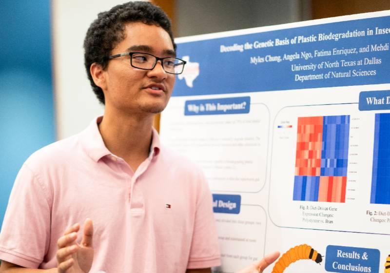 Photo of Myles Chung explaining the superworm plastics project at the 2025 UNT Dallas Student Research Symposium 