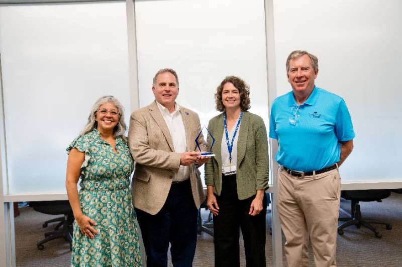 Photo of President Warren von Eschenbach and Kim Chandler, Associate VP for Strategy and Effectiveness, Receive the 2024 Texas University Report Card Award from ScholarShot's Dan Hooper and Christina Etri 