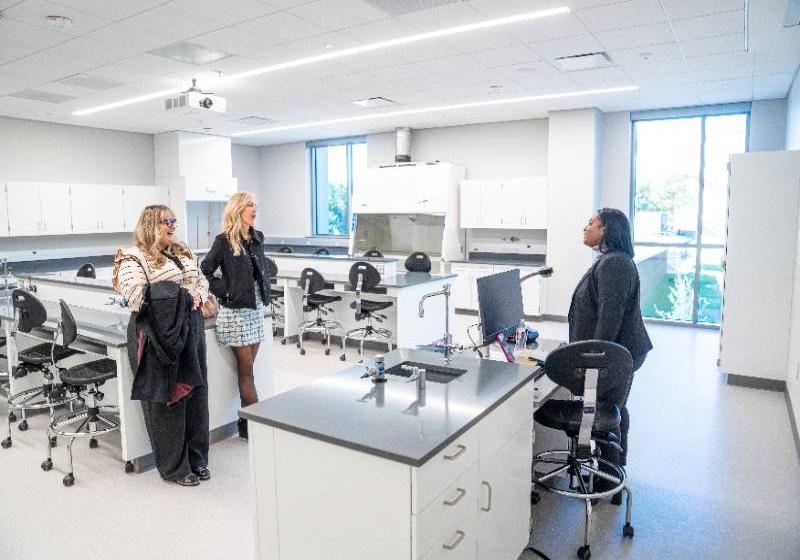 Photo of UNT Dallas Biology Professor Dr. Aubrey Frantz (middle) and Dean of Students Jennifer Skinner (left) speak with senior Princess Johnson in a new science lab