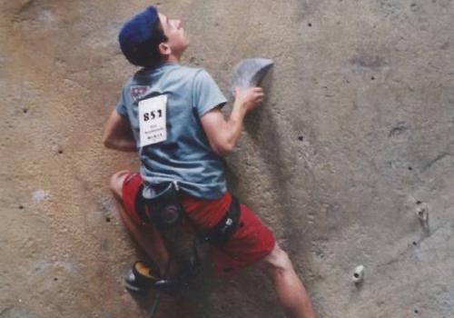 Photo of Stan Borodyansky, at 14, climbing a rock wall during a competition 