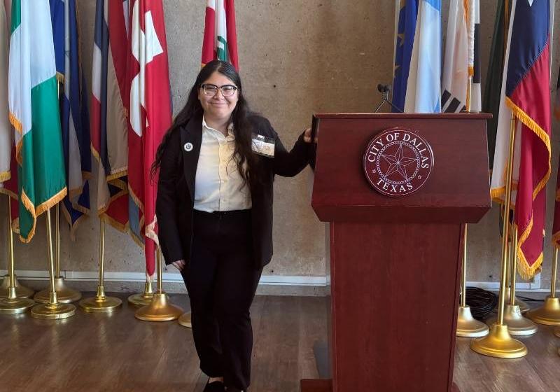 UNT Dallas's Julisa Morones at the Dallas City Hall Photo of UNT Dallas's Julisa Morones standing next to a podium at the Dallas City Hall