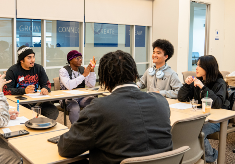 Photo of UNT Dallas's Myles Chung in a science classroom discussion group 