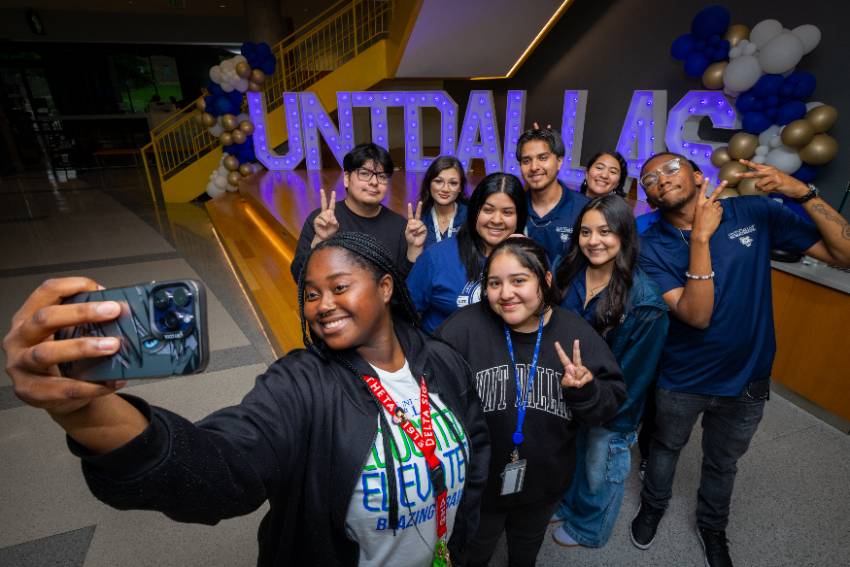 Photo of a UNT Dallas students taking a selfie in front of large lit letters that spell out UNT Dallas at 2025 UNT Dallas new student orientation 