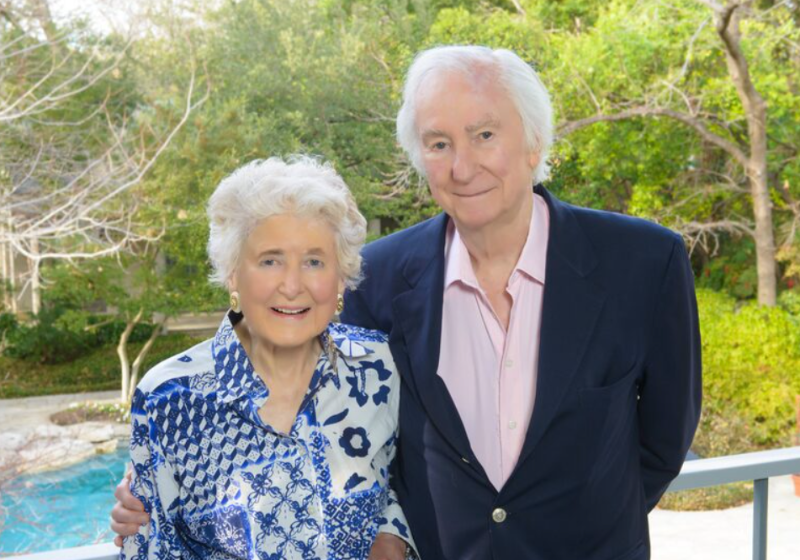A close-up portrait photo of the late Edith and Peter O'Donnell standing outside in front of some trees and a pond (courtesy UT Southwestern) 