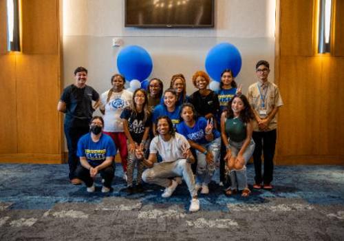 Photo of Yolanda Lewis (upper row, second from left) with 12 fellow members of Trailblazer Elite at a group mixer 
