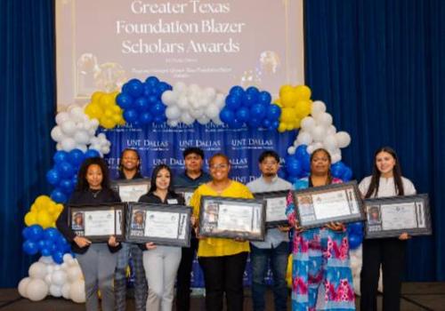 Photo of Yolanda Lewis (second from right) holding her award at the 2025 Student Leadership and Success year-end celebration with eight other students holding their own awards