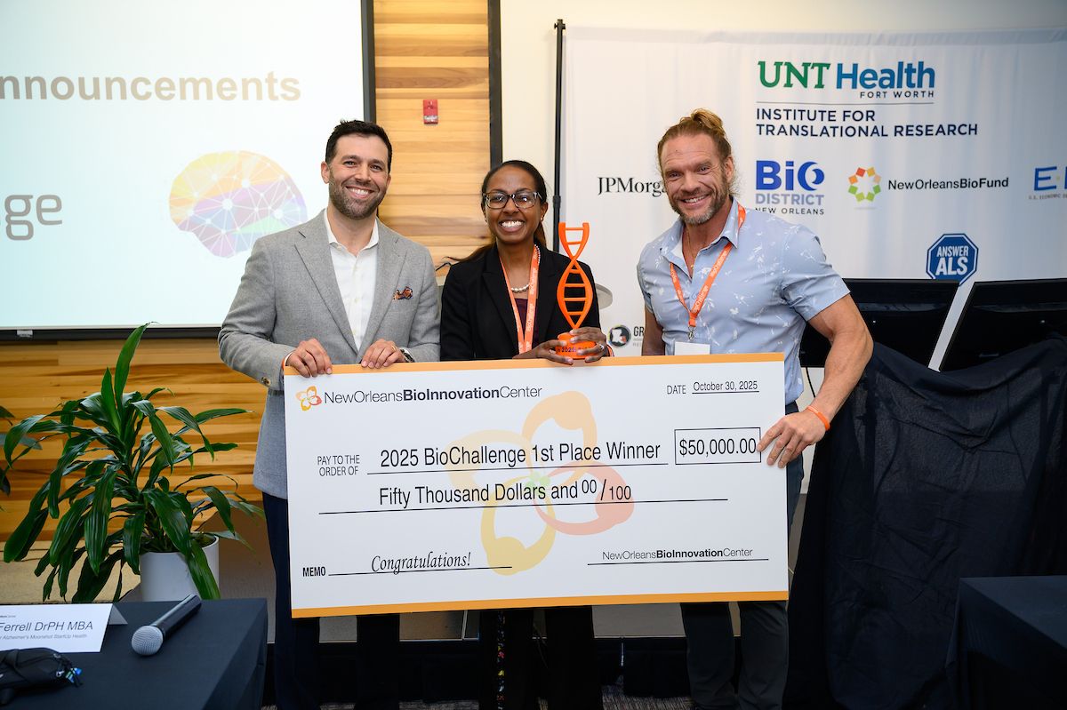 Three people are smiling and posing for a photo holding a 1st place award and oversized check at the New Orleans BioInnovation Center BioChallenge Pitch Competition,