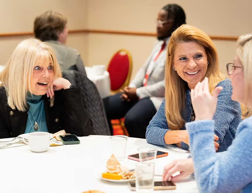 Photo of Karen Komondor, U.S. Health Literacy Association (on left) with UNT Health's Dr. Teresa Wagner (on right) and other professionals networking and engaging in conversation during last year's Health Literacy Collaborative Summit.