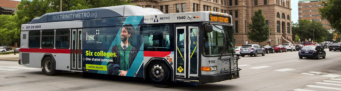Top horizontal photo banner of the University of North Texas Health Science Center at Fort Worth's award-winning ad on the side of a Trinity Metro bus on the street in front of the City of Fort Worth's courthouse