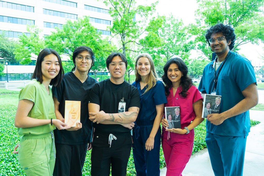 A photo of six UNTHSC's TCOP's 2024-25 Legacy Writers standing together. Three of them are holding a book