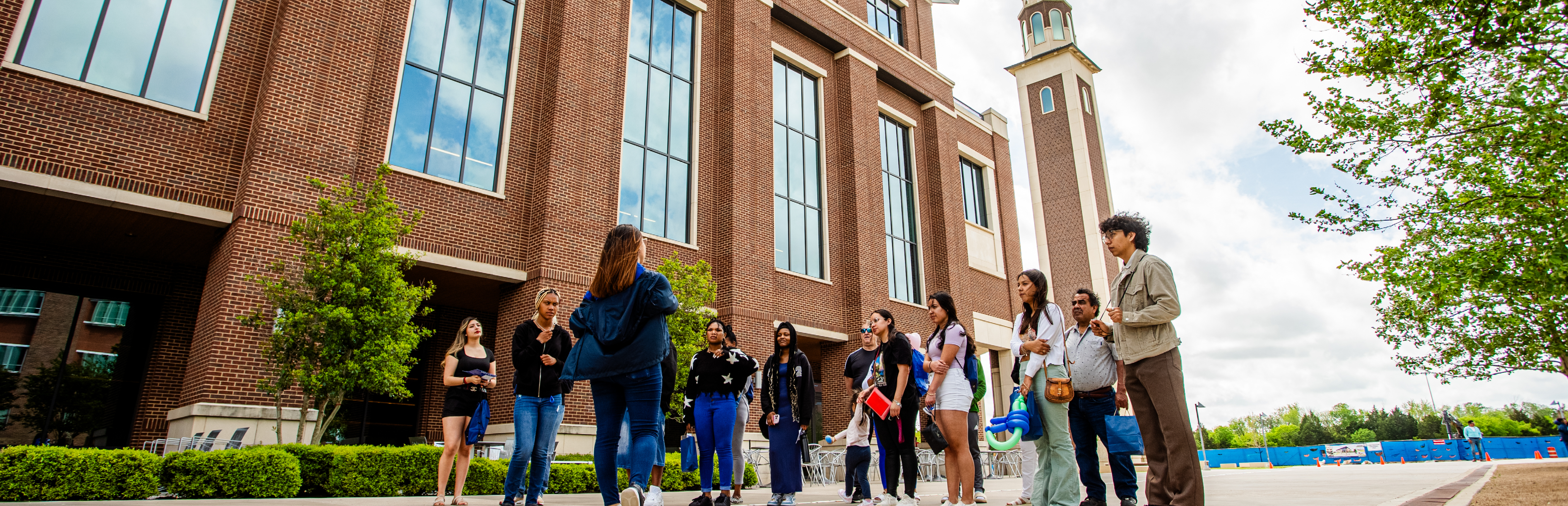 Alt Text: University of North Texas Dallas campus entrance sign with official university seal on a sunny day.