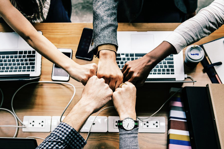 Several hands meeting in the middle